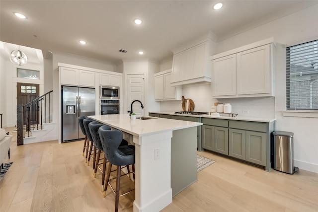 12104 Fairway Meadows Dr, Fort Worth, TX 76179 - kitchen featuring appliances with stainless steel finishes, light wood-type flooring, crown molding, a kitchen bar, and a center island with sink