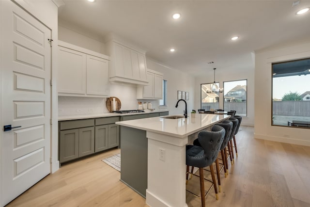 12104 Fairway Meadows Dr, Fort Worth, TX 76179 - kitchen with gray cabinets, light wood-style floors, an island with sink, recessed lighting, and light countertops