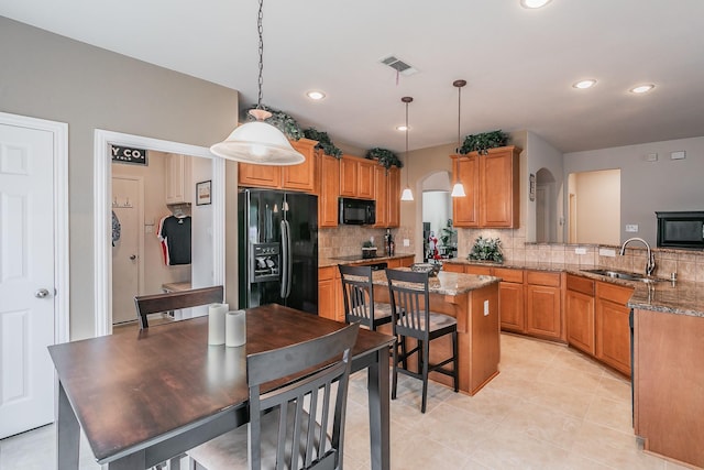4757 Van Zandt Dr, Fort Worth, TX 76244 - kitchen with black appliances, a sink, arched walkways, tasteful backsplash, and a peninsula