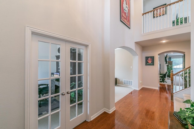 4757 Van Zandt Dr, Fort Worth, TX 76244 - foyer with arched walkways, french doors, wood finished floors, baseboards, and a towering ceiling