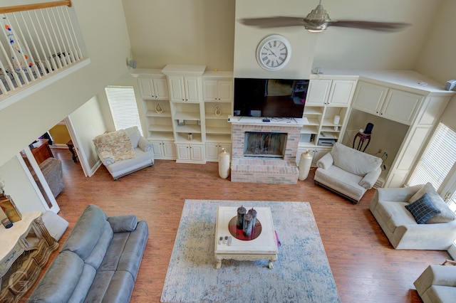 5345 Vermilion Pl, Keithville, LA 71047 - living area featuring light wood-type flooring, plenty of natural light, high vaulted ceiling, a ceiling fan, and a brick fireplace