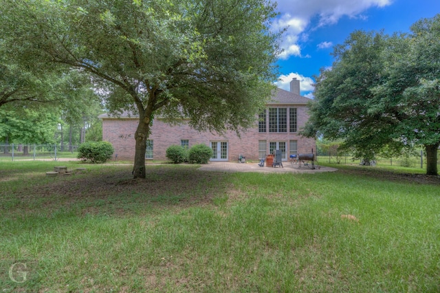 5345 Vermilion Pl, Keithville, LA 71047 - rear view of house with french doors, a patio, a chimney, and brick siding