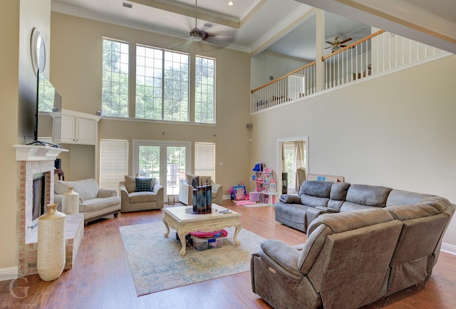 5345 Vermilion Pl, Keithville, LA 71047 - living room featuring a ceiling fan, a high ceiling, ornamental molding, a brick fireplace, and wood finished floors