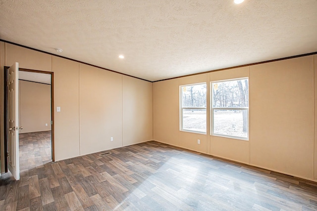 1613 Mockingbird Ln, Pelican Bay, TX 76020 - empty room featuring wood finished floors, a textured ceiling, crown molding, a decorative wall, and recessed lighting