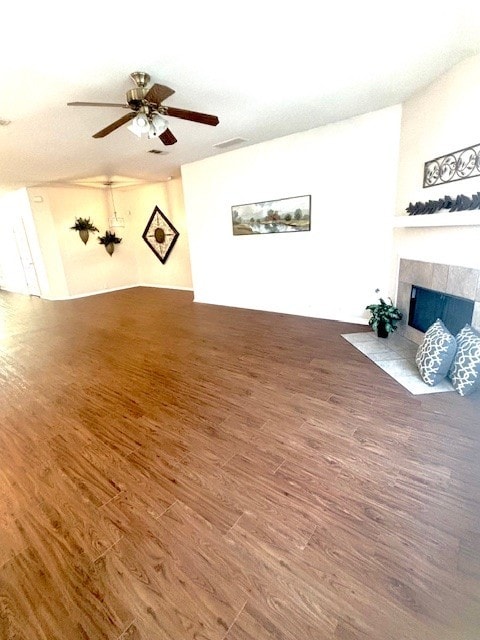 8309 Horse Whisper Ln, Fort Worth, TX 76131 - unfurnished living room with wood finished floors, a tiled fireplace, and ceiling fan