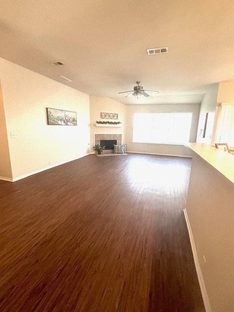 8309 Horse Whisper Ln, Fort Worth, TX 76131 - unfurnished living room featuring baseboards, ceiling fan, dark wood-style floors, and a tile fireplace