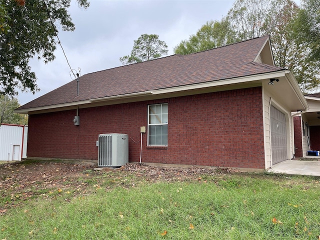 21992 Fm 226, Etoile, TX 75944 - view of side of property featuring central AC unit, brick siding, a shingled roof, an attached garage, and a lawn