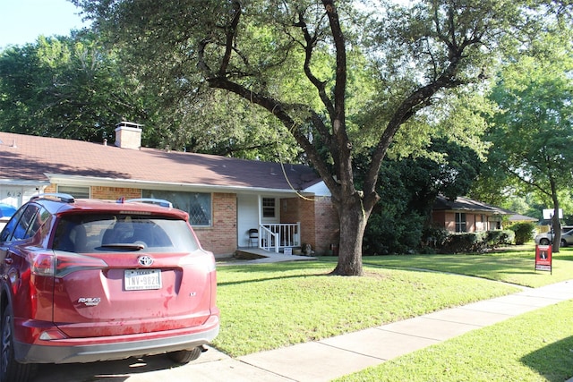 612 Ranier Cir, Garland, TX 75041 - ranch-style house with brick siding, a front yard, and a chimney