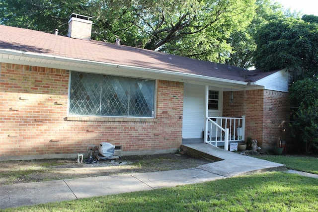612 Ranier Cir, Garland, TX 75041 - view of front of home with a chimney, brick siding, and roof with shingles