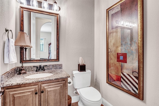 2305 Kemerton, Plano, TX 75025 - bathroom featuring baseboards, toilet, vanity, and a textured wall