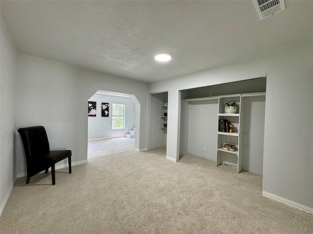 3107 Hale Ave, Fort Worth, TX 76106 - unfurnished bedroom featuring arched walkways, light colored carpet, a textured ceiling, and baseboards
