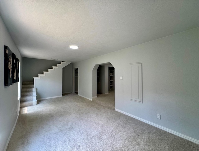 3107 Hale Ave, Fort Worth, TX 76106 - unfurnished room with light colored carpet, arched walkways, stairway, baseboards, and a textured ceiling