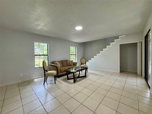 3107 Hale Ave, Fort Worth, TX 76106 - living area featuring light tile patterned floors, stairs, a textured ceiling, and baseboards