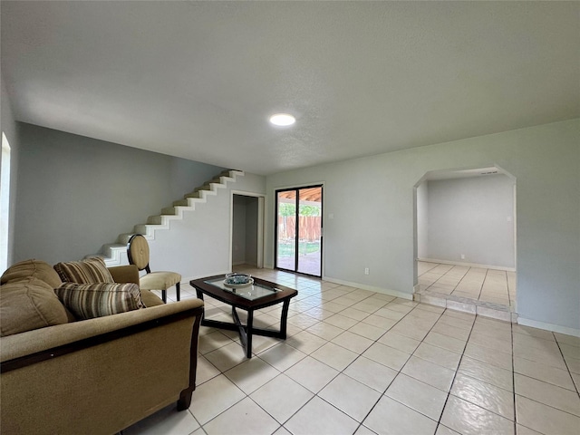 3107 Hale Ave, Fort Worth, TX 76106 - living room with light tile patterned floors, stairs, baseboards, arched walkways, and recessed lighting