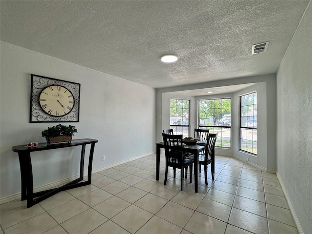 3107 Hale Ave, Fort Worth, TX 76106 - dining space with a textured ceiling, light tile patterned floors, a textured wall, and baseboards