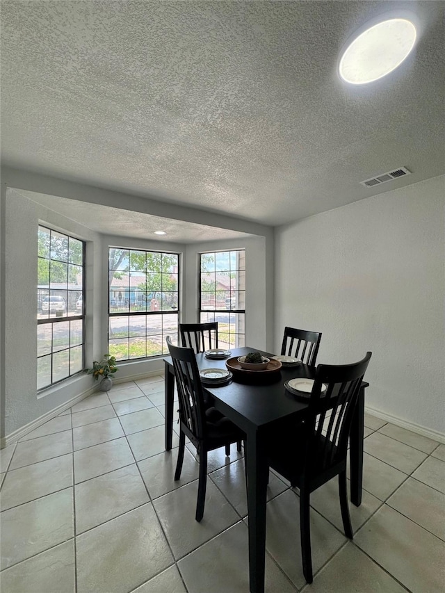 3107 Hale Ave, Fort Worth, TX 76106 - dining room with a textured ceiling, light tile patterned floors, and baseboards
