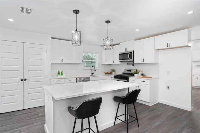 214 Betty Dr, Richardson, TX 75081 - kitchen featuring stainless steel appliances, dark wood-style flooring, white cabinetry, pendant lighting, and recessed lighting
