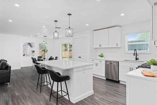 214 Betty Dr, Richardson, TX 75081 - kitchen featuring dishwasher, a center island, a sink, dark wood finished floors, and a kitchen bar