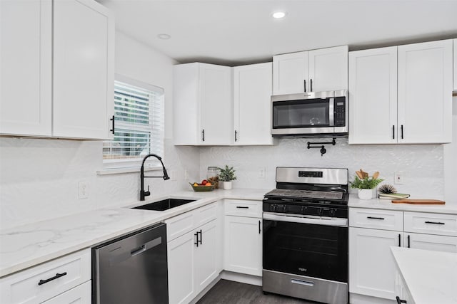 214 Betty Dr, Richardson, TX 75081 - kitchen featuring stainless steel appliances, a sink, white cabinetry, tasteful backsplash, and light stone counters