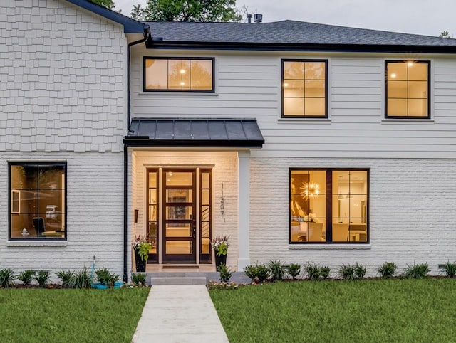 11207 Dwarfs Cir, Dallas, TX 75229 - entrance to property featuring brick siding, a standing seam roof, a lawn, and a metal roof