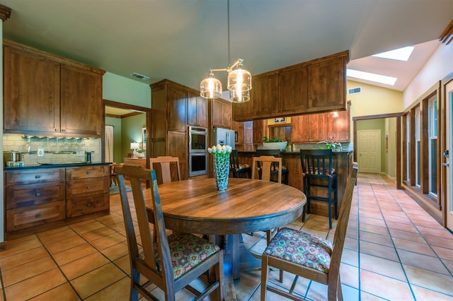 17889 County Road 134, Flint, TX 75762 - dining room featuring light tile patterned floors, a skylight, vaulted ceiling, and a chandelier