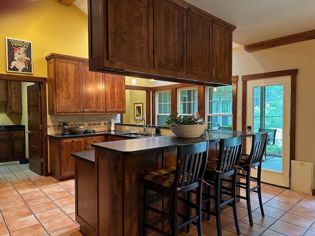 17889 County Road 134, Flint, TX 75762 - kitchen with a sink, light tile patterned flooring, dark countertops, and decorative backsplash