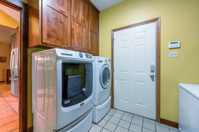 17889 County Road 134, Flint, TX 75762 - laundry area featuring independent washer and dryer, cabinet space, light tile patterned floors, and baseboards