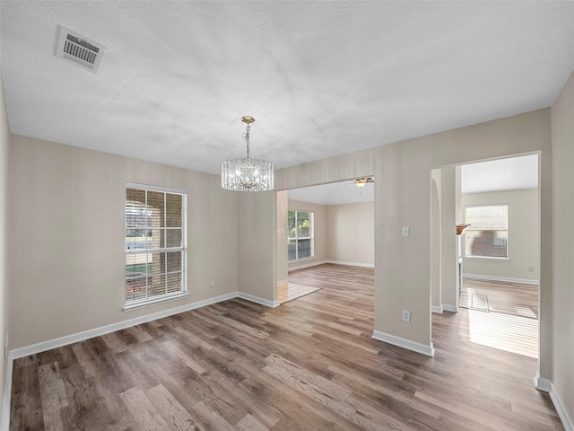 1409 Rivercrest Blvd, Allen, TX 75002 - unfurnished room featuring a chandelier, wood finished floors, baseboards, and a textured ceiling