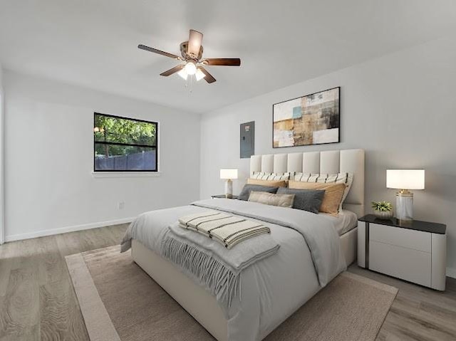 6825 John Dr, Richland Hills, TX 76118 - bedroom featuring electric panel, light wood-type flooring, a ceiling fan, and baseboards