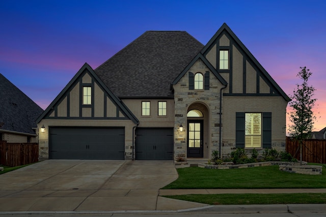 504 Arrowhead Ln, Haslet, TX 76052 - tudor-style house featuring stone siding, concrete driveway, a shingled roof, stucco siding, and a garage