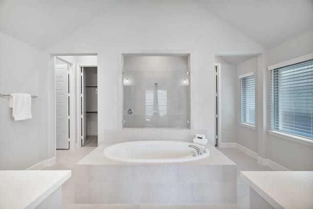 504 Arrowhead Ln, Haslet, TX 76052 - bathroom featuring lofted ceiling, a garden tub, a tile shower, and a walk in closet