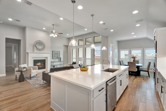 504 Arrowhead Ln, Haslet, TX 76052 - kitchen featuring dishwasher, light wood finished floors, a glass covered fireplace, a ceiling fan, and recessed lighting