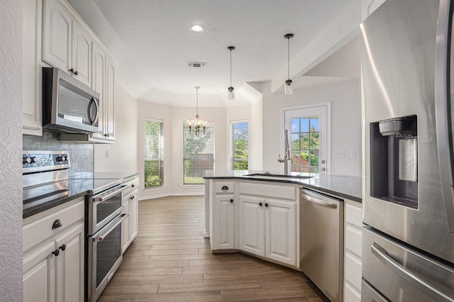2109 Timber Cove Ct, Weatherford, TX 76087 - kitchen featuring stainless steel appliances, dark countertops, plenty of natural light, and recessed lighting