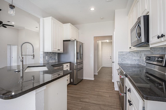 2109 Timber Cove Ct, Weatherford, TX 76087 - kitchen featuring appliances with stainless steel finishes, a sink, a peninsula, baseboards, and decorative backsplash
