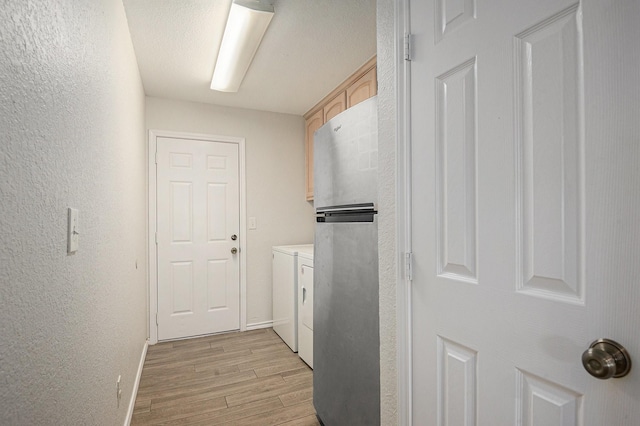 2109 Timber Cove Ct, Weatherford, TX 76087 - hall featuring washing machine and clothes dryer, light wood-style floors, baseboards, and a textured wall