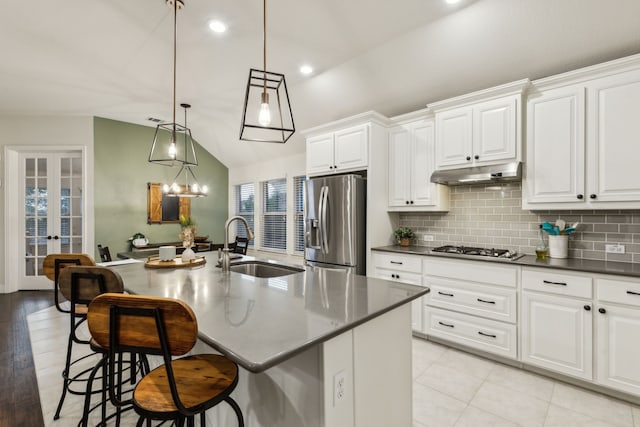 10113 Warberry Trl, Fort Worth, TX 76131 - kitchen featuring appliances with stainless steel finishes, a sink, under cabinet range hood, vaulted ceiling, and backsplash
