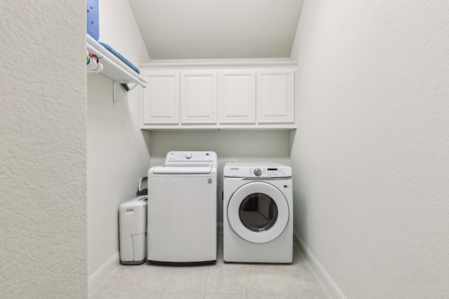 10113 Warberry Trl, Fort Worth, TX 76131 - laundry area with cabinet space, separate washer and dryer, baseboards, light tile patterned floors, and a textured wall