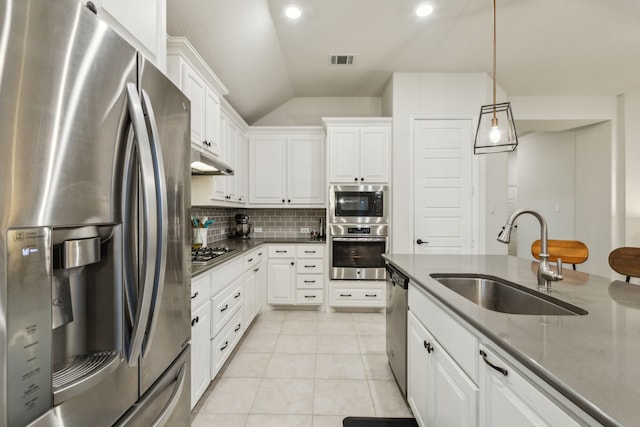 10113 Warberry Trl, Fort Worth, TX 76131 - kitchen featuring appliances with stainless steel finishes, a sink, vaulted ceiling, decorative backsplash, and white cabinets