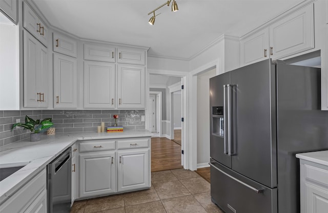 213 Redwood Ct, Keller, TX 76248 - kitchen featuring appliances with stainless steel finishes, decorative backsplash, light tile patterned flooring, and white cabinets