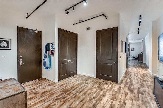 1122 Jackson St Unit 220, Dallas, TX 75202 - entryway with light wood-style flooring, baseboards, and track lighting