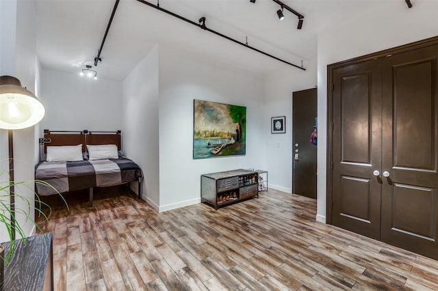 1122 Jackson St Unit 220, Dallas, TX 75202 - bedroom featuring track lighting, light wood-style flooring, and baseboards