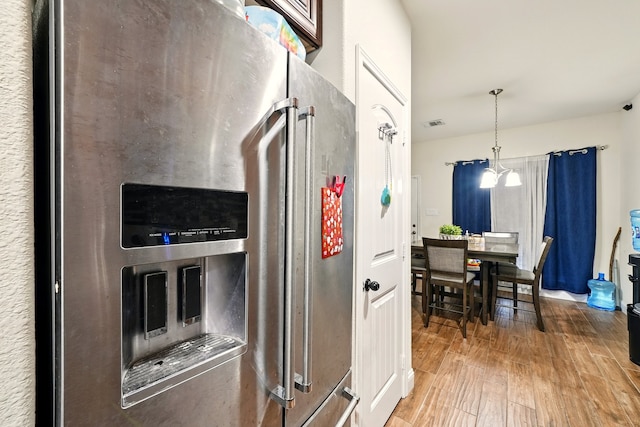 2901 18th St, Fort Worth, TX 76106 - kitchen featuring stainless steel refrigerator with ice dispenser, wood finished floors, and pendant lighting