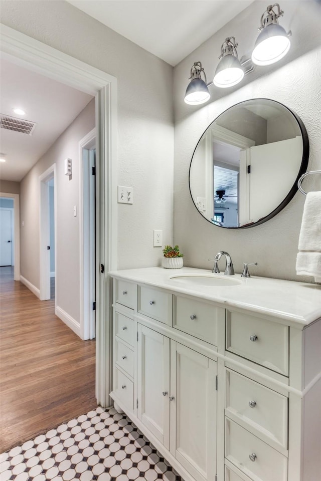 9139 Bretshire Dr, Dallas, TX 75228 - bathroom with vanity, a ceiling fan, wood finished floors, and baseboards