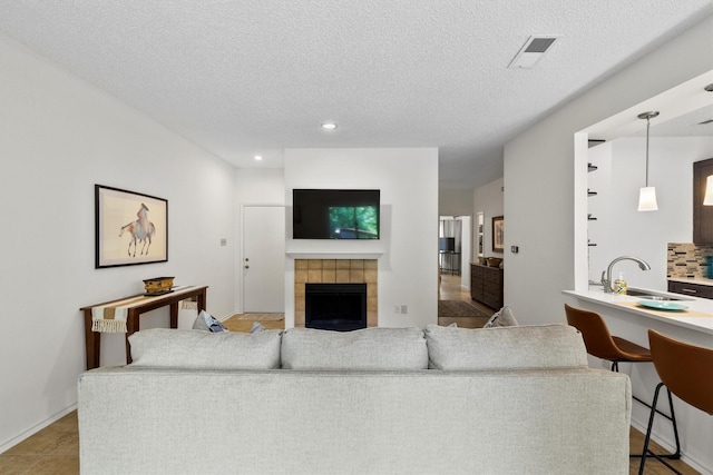 2506 Wedglea Dr Unit 907, Dallas, TX 75211 - living room with a fireplace, a textured ceiling, and recessed lighting