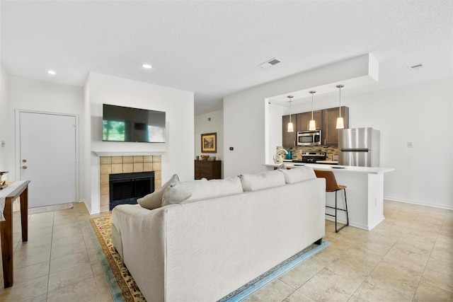 2506 Wedglea Dr Unit 907, Dallas, TX 75211 - living area with a fireplace, recessed lighting, a textured ceiling, light tile patterned floors, and baseboards