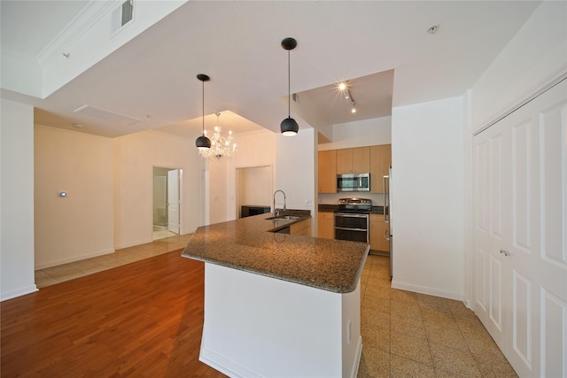 3225 Turtle Creek Blvd Unit 320, Dallas, TX 75219 - kitchen featuring appliances with stainless steel finishes, a sink, a chandelier, open floor plan, and pendant lighting