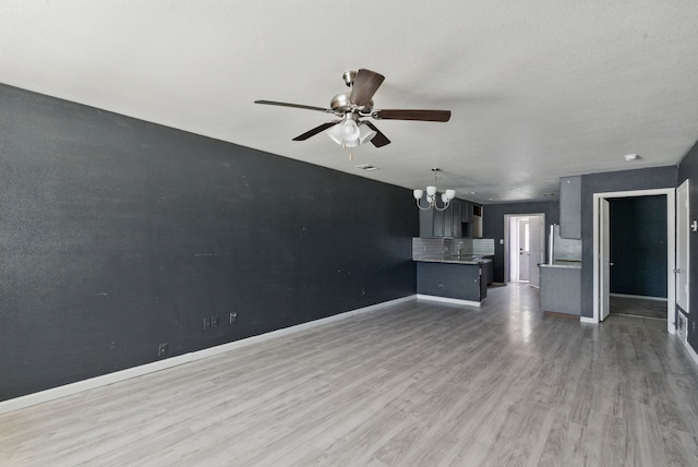 5608 Humbert Ave, Fort Worth, TX 76107 - unfurnished living room featuring a chandelier, a ceiling fan, wood finished floors, and baseboards