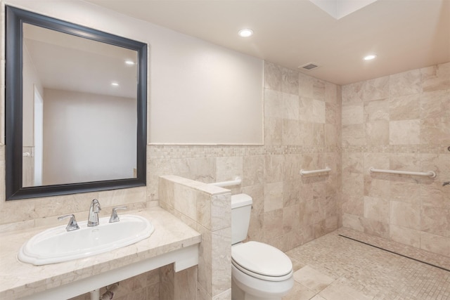 6335 W NW Hwy Unit 1314, Dallas, TX 75225 - bathroom featuring a sink, toilet, recessed lighting, tile walls, and tile patterned flooring