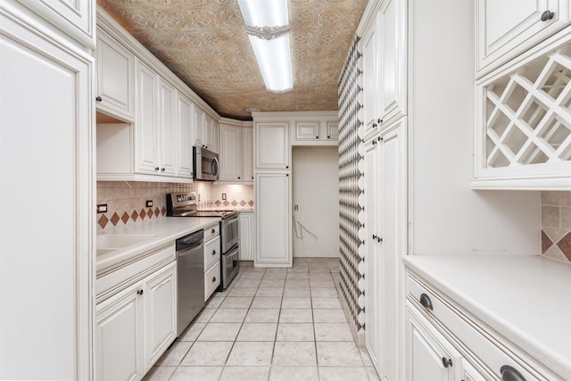 6335 W NW Hwy Unit 1314, Dallas, TX 75225 - kitchen with stainless steel appliances, decorative backsplash, white cabinetry, light countertops, and an ornate ceiling