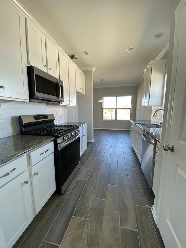 523 Long Pr, Royse City, TX 75189 - kitchen with appliances with stainless steel finishes, white cabinetry, dark wood-style flooring, crown molding, and tasteful backsplash